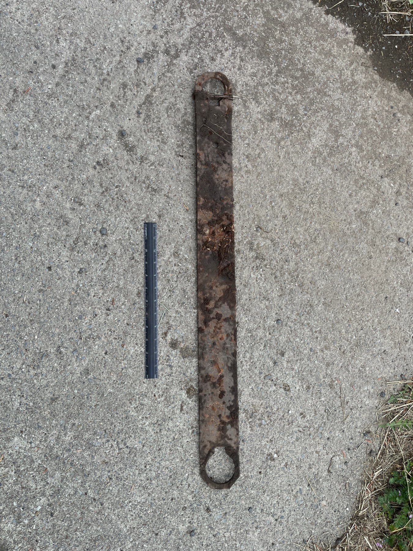 A rusted iron bar next to a ruler.